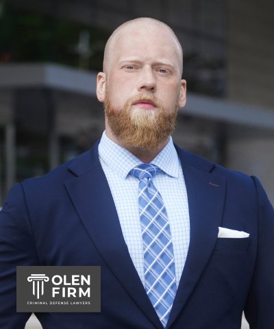 Jared Olen is in a suit, standing outside, wearing a blue tie. The logo in the corner reads "Olen Firm."