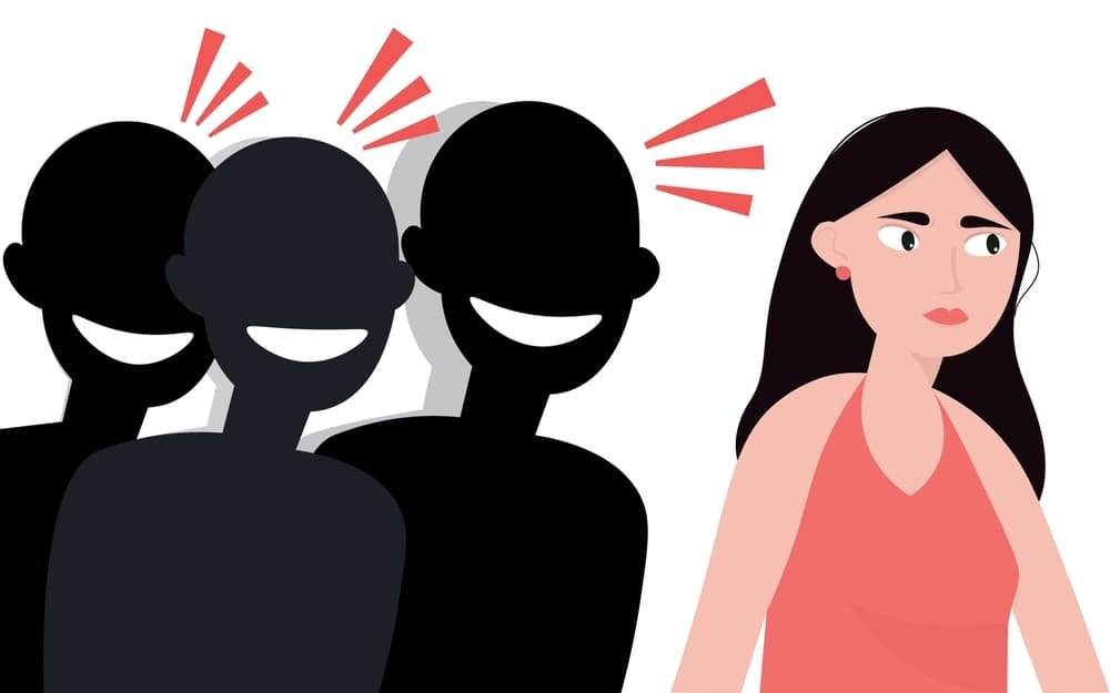 The image depicts a woman looking uncomfortable or unhappy while three silhouetted figures behind her are laughing. 