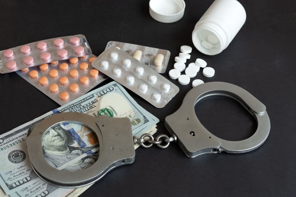 Composition of drugs and handcuffs with selective focus. Concept of crime and illegal money.