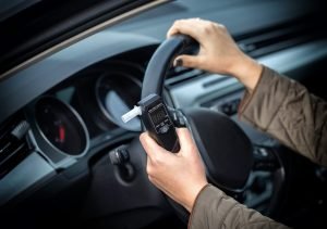 Handheld breathalyzer device inside a vehicle, illustrating BAC defense scenarios in Pasadena DUI cases.